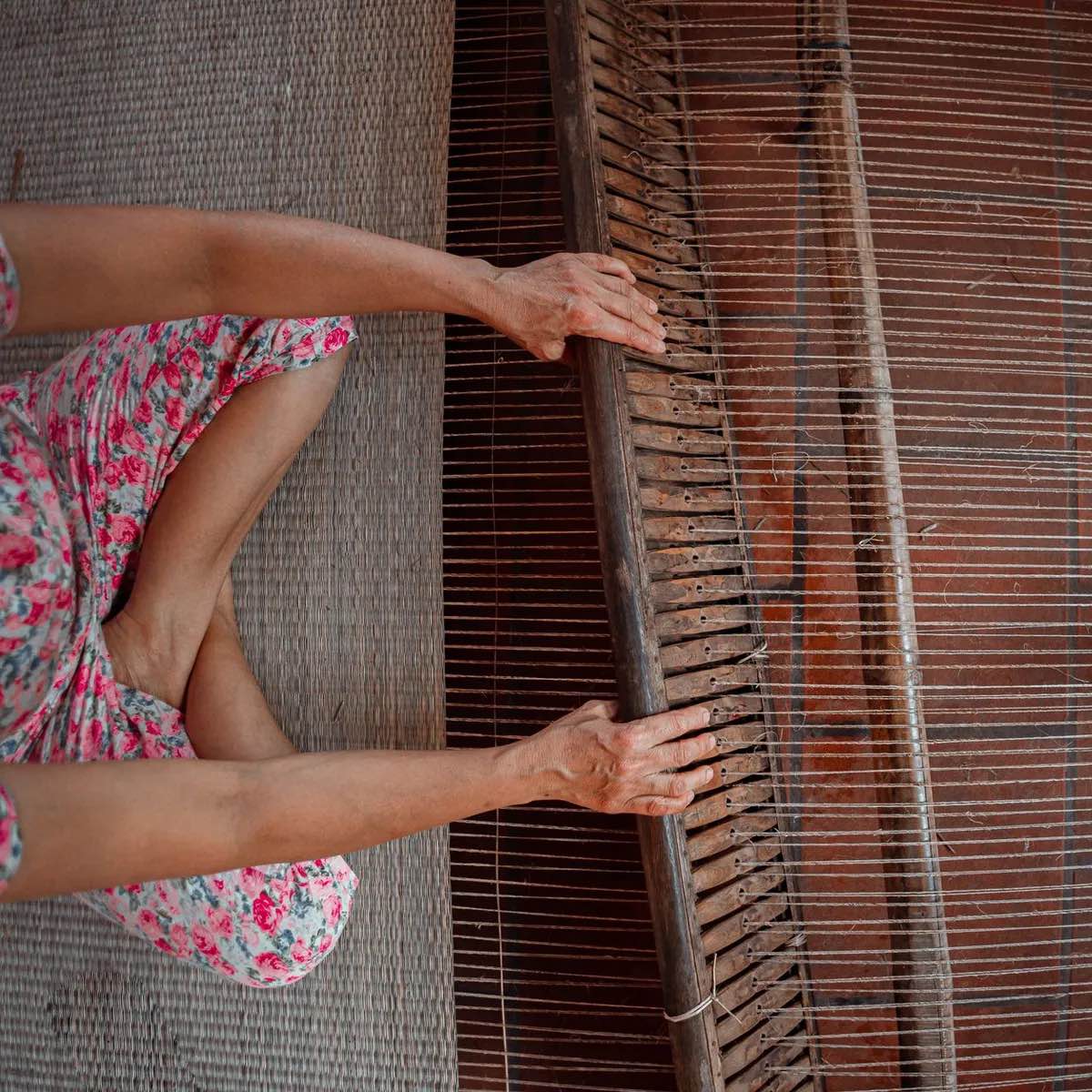 Artisan weaving fabric on a wooden handloom